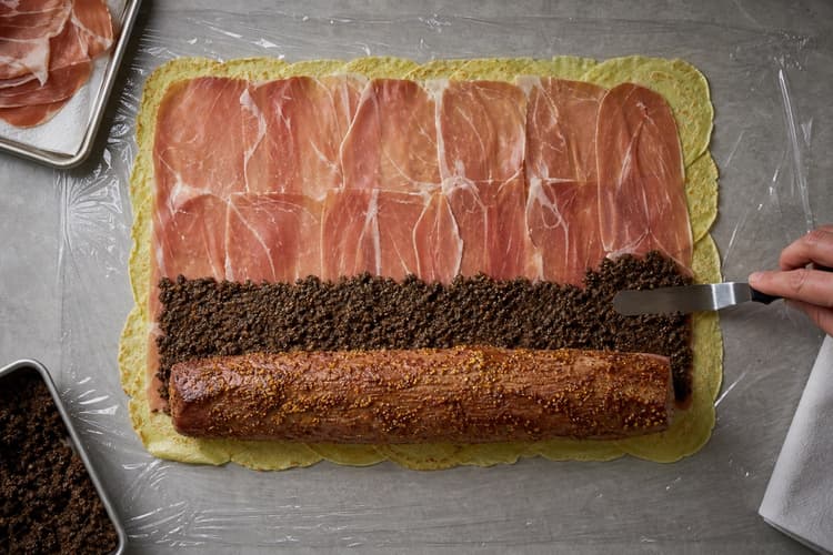 Beef Wellington method step 5, Roll the modern dual barrier: A cold, firm, gap-free cylinder has no exposed beef, air pockets, mushroom bulges, or loose ends.