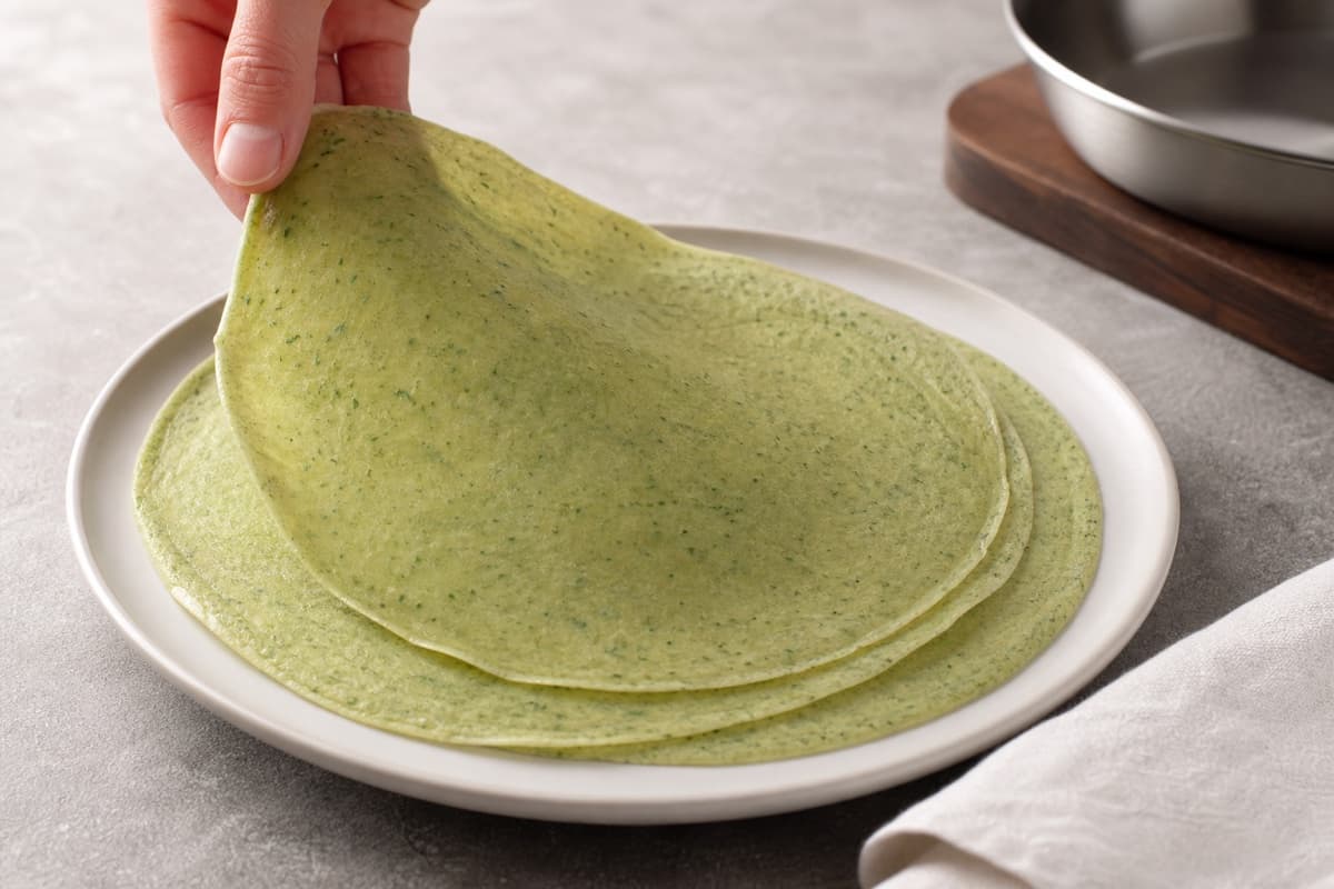 Beef Wellington, step 3, Make paper-thin green crêpes: Pale-green sheets are flexible, dry to the touch, almost translucent at the edge, and show little or no browning.