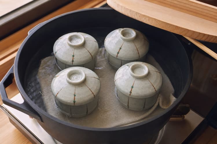 Chawanmushi method step 5, Steam at the quietest simmer: Water gives an occasional quiet plop; cups do not rattle and no rolling boil is visible.