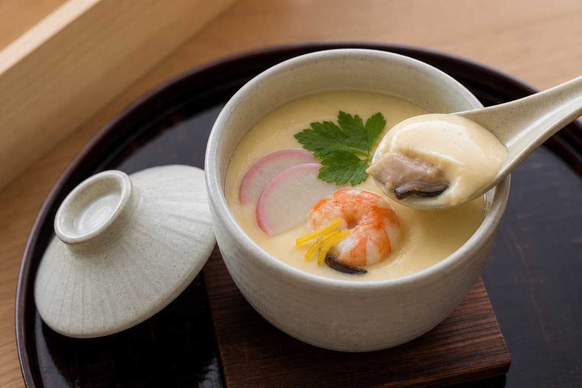 Chawanmushi, step 7, Rest covered, garnish, and spoon: The glossy pale custard trembles softly and spoons like silk between soft tofu and barely set custard.