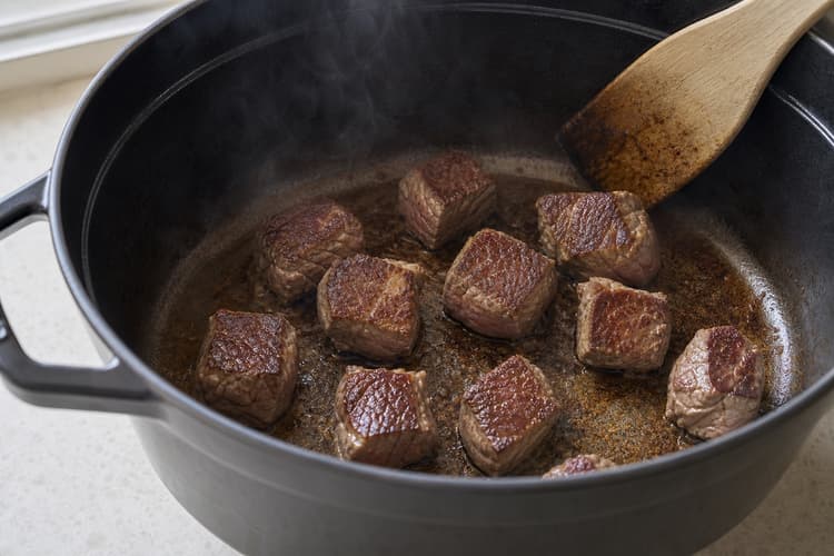 Chinese Tomato Beef Stew method step 3, Brown in uncrowded batches: Dry mahogany patches contrast with paler edges, and the pot holds clean brown fond with no black residue.