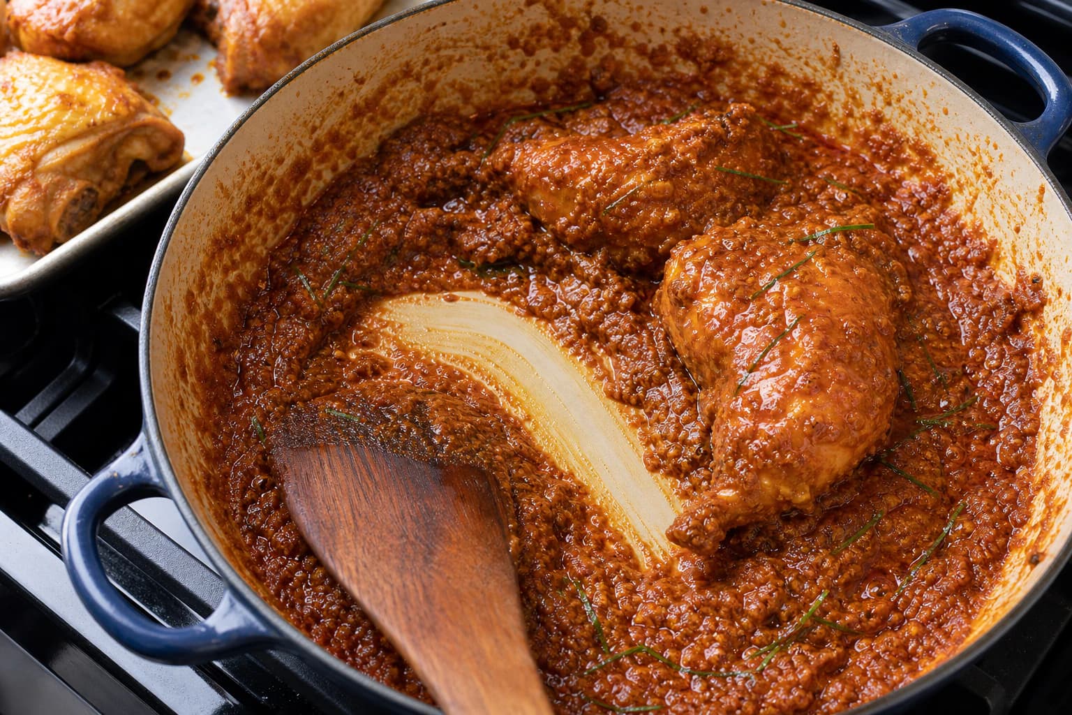 Penang Nyonya Kari Kapitan, step 6, Reduce to the Kapitan cling: A spatula trail exposes the pot for 2–3 seconds and sauce drops slowly from each lacquered piece without a watery edge.