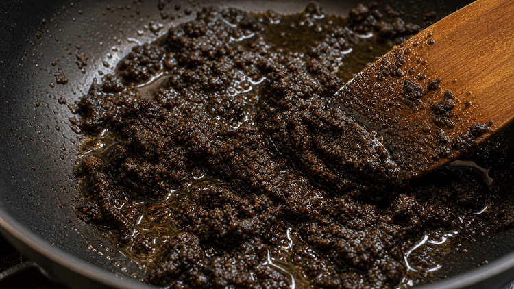 Rawon method step 2, Bloom the paste: Glossy dark paste with oil sheen.