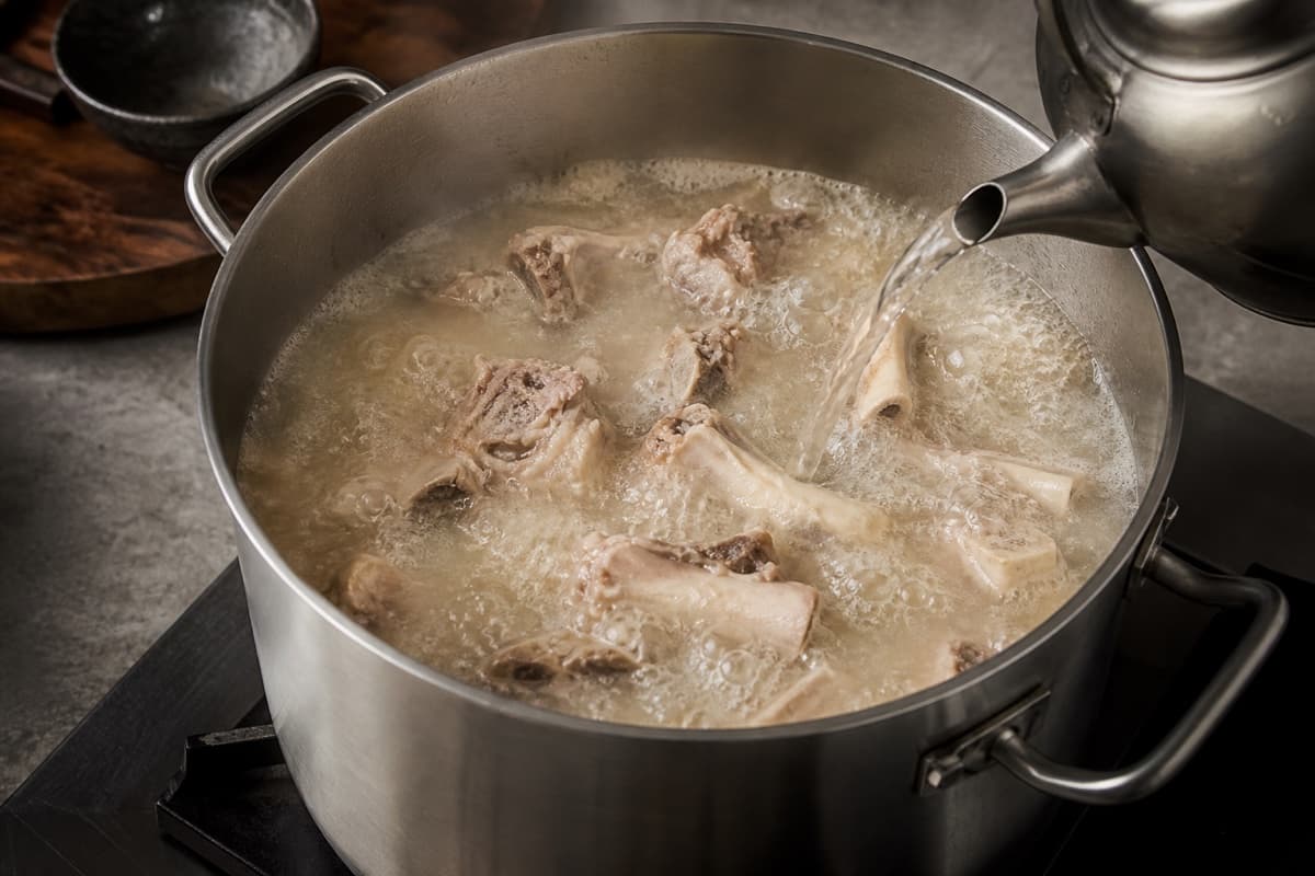 Tonkotsu Shoyu Ramen, step 3, Drive the paitan with a controlled rolling boil: Constant turbulence moves the bones and the liquid changes progressively from clear to opaque ivory without dairy.